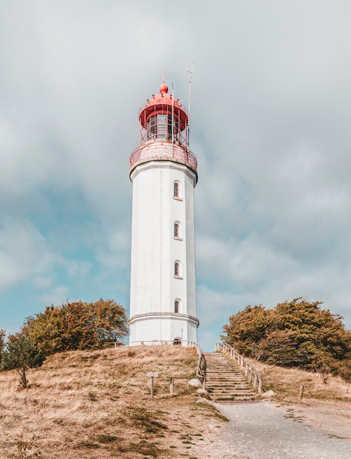 creative-03 Picturesque lighthouse tower standing tall with a blue sky background, perfect for travel themes.