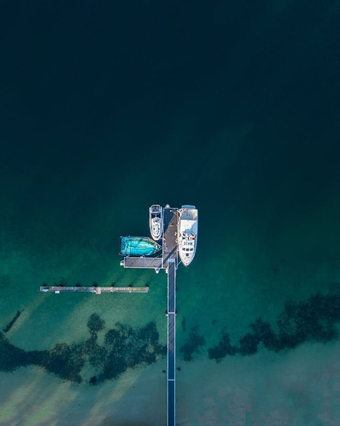 Aerial photography capturing moored boats and clear waters at a Sydney dock.