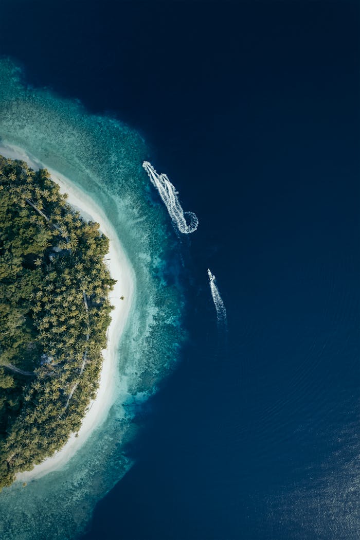 brand-03 Stunning aerial shot of a tropical beach with boats in clear waters of Papua, Indonesia.