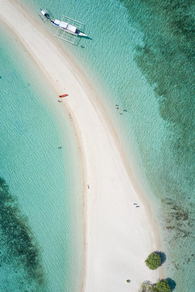 pexels-photo-4144736 Aerial view showcasing a pristine white sand beach with turquoise water in the Philippines.